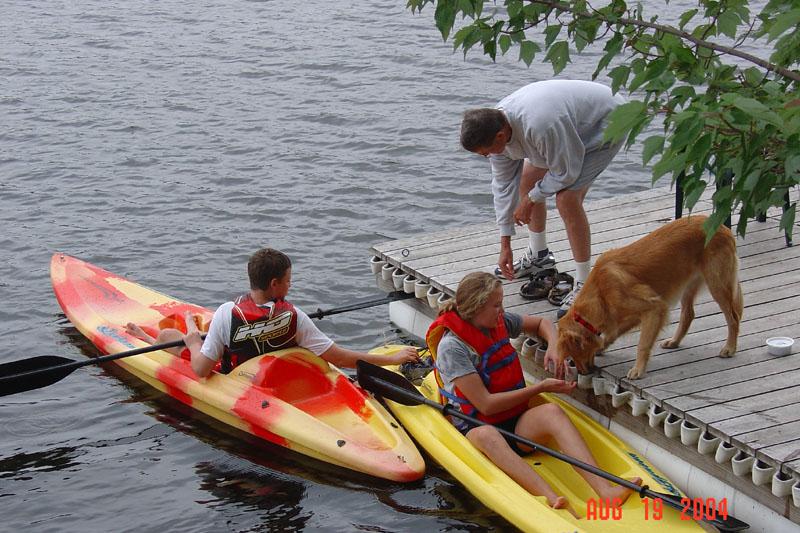 kids kayaking with dog and dad